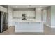 Bright, open kitchen with white cabinets, stainless steel appliances, and a large center island for food preparation at 16551 W Desert Ln, Goodyear, AZ 85338