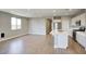Bright kitchen and living area with white cabinets, stainless steel appliances, and wood-look flooring at 16551 W Desert Ln, Goodyear, AZ 85338