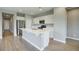 Open-concept kitchen featuring white cabinets, stainless steel appliances, and a spacious center island with bar seating at 16551 W Desert Ln, Goodyear, AZ 85338