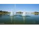 Picturesque lake featuring water fountain and lush greenery, creating a serene oasis for residents to enjoy at 16551 W Desert Ln, Goodyear, AZ 85338