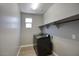 Modern laundry room with a new black washer and dryer at 16551 W Desert Ln, Goodyear, AZ 85338