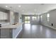 Open living area with wood-style tile flooring, modern lighting, and sliding glass doors to the backyard at 16551 W Desert Ln, Goodyear, AZ 85338