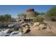 Beautiful water feature with stacked stones and desert plants, creating a serene and inviting atmosphere at 16551 W Desert Ln, Goodyear, AZ 85338