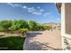 Spacious backyard featuring a brick patio, mature landscaping, and stunning mountain views at 17520 W Fairview St, Goodyear, AZ 85338