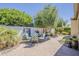 Beautiful backyard patio features pavers, mature landscaping, and stylish outdoor furniture, perfect for entertaining at 1776 E Laddoos Ave, Queen Creek, AZ 85140