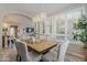 Bright dining room features a wood table, elegant chairs, chandelier, and large windows with plantation shutters at 1776 E Laddoos Ave, Queen Creek, AZ 85140