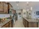 Updated kitchen featuring stainless steel appliances, granite counters and a kitchen island with pendant lighting at 1776 E Laddoos Ave, Queen Creek, AZ 85140