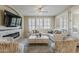 Cozy living room featuring a stone fireplace, plush seating, and abundant natural light from shuttered windows at 1776 E Laddoos Ave, Queen Creek, AZ 85140