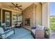 Covered patio featuring a brick fireplace, comfortable seating, and a ceiling fan for added comfort at 1776 E Laddoos Ave, Queen Creek, AZ 85140