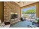 Cozy patio with brick fireplace, comfortable seating, and an outdoor dining area beyond the opening at 1776 E Laddoos Ave, Queen Creek, AZ 85140