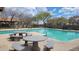 Inviting community pool featuring tables, benches, and lounge chairs for relaxing and socializing in a lush setting at 18224 W La Senda Dr, Surprise, AZ 85387