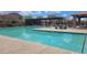 Large community pool area with plenty of seating, tables, a covered area, and meticulously kept landscaping at 18224 W La Senda Dr, Surprise, AZ 85387