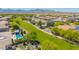 Wide aerial view of a lush greenbelt with walking paths and community pools, set against a mountain backdrop at 18419 W Maui Ln, Surprise, AZ 85388