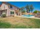 Spacious backyard with lush green grass, a pool, patio, and outdoor seating at 18419 W Maui Ln, Surprise, AZ 85388