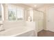 Bright bathroom with a tub under a window and a separate glass enclosed shower at 18419 W Maui Ln, Surprise, AZ 85388