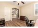 Bedroom with wood floors, ceiling fan, open archway, and desk at 18419 W Maui Ln, Surprise, AZ 85388