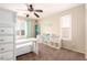 Bright bedroom with a desk, shelving, and a window with plantation shutters at 18419 W Maui Ln, Surprise, AZ 85388