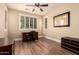 Bedroom with plantation shutters, wood floors, ceiling fan, and a desk perfect for a home office at 18419 W Maui Ln, Surprise, AZ 85388
