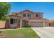 Charming two-story home with a three car garage, landscaped front yard, and beautiful desert flowers at 18419 W Maui Ln, Surprise, AZ 85388