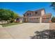 Charming two-story home with a three car garage, landscaped front yard, and desert flowers in view at 18419 W Maui Ln, Surprise, AZ 85388