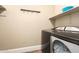 A functional laundry room equipped with modern appliances and convenient storage shelves at 18419 W Maui Ln, Surprise, AZ 85388