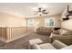 Loft space with cozy seating, bright windows, and ceiling fan with open rail to the staircase at 18419 W Maui Ln, Surprise, AZ 85388