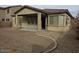 An open backyard with minimal landscaping and a covered patio that is attached to the home at 18447 W Verdin Rd, Goodyear, AZ 85338