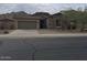 Beautiful one-story home with stone exterior, three car garage and desert landscaping at 18447 W Verdin Rd, Goodyear, AZ 85338