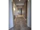 A long hallway with tile floors that leads to rooms with carpet and large windows at 18447 W Verdin Rd, Goodyear, AZ 85338