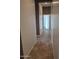 Long hallway with tile flooring that leads to carpeted bedrooms at 18447 W Verdin Rd, Goodyear, AZ 85338