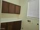 Laundry room featuring a window and cabinets above and below the counter space at 18447 W Verdin Rd, Goodyear, AZ 85338