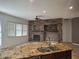 Inviting living room with a brick fireplace, granite countertops, and plenty of natural light at 18447 W Verdin Rd, Goodyear, AZ 85338