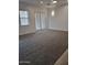 Large living room with grey carpeting, bright lighting, and large windows at 18447 W Verdin Rd, Goodyear, AZ 85338