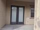 Double doors leading from the house to a covered patio with grey concrete at 18447 W Verdin Rd, Goodyear, AZ 85338
