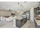 Open concept kitchen features an island with bar seating, modern appliances, and flows into the living area at 18530 E Mockingbird Ct, Queen Creek, AZ 85142