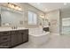 Spacious bathroom featuring a luxurious soaking tub, double vanities, and stylish decor at 18530 E Mockingbird Ct, Queen Creek, AZ 85142