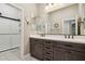 Well-lit bathroom features a double sink vanity with dark wood cabinets and a glass-enclosed shower at 18530 E Mockingbird Ct, Queen Creek, AZ 85142