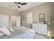 Light-filled bedroom features modern decor, a ceiling fan, and a dresser with white drawers at 18530 E Mockingbird Ct, Queen Creek, AZ 85142