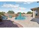 Inviting backyard pool features a baja step, nearby fire pit, and beautiful desert landscaping at 18530 E Mockingbird Ct, Queen Creek, AZ 85142
