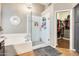 Bathroom featuring a glass enclosed shower, soaking tub, and a glimpse into the walk-in closet at 20608 N 57Th Ave, Glendale, AZ 85308