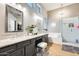 Bright bathroom with dual sinks, granite counters, tiled walk-in shower, and soaking tub at 20608 N 57Th Ave, Glendale, AZ 85308