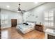 Spacious primary bedroom featuring wood floors, plantation shutters, ceiling fan, and decor at 20608 N 57Th Ave, Glendale, AZ 85308