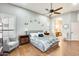 Bright primary bedroom with wood floors, plantation shutters, ceiling fan, and en suite bathroom access at 20608 N 57Th Ave, Glendale, AZ 85308