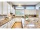 Elegant kitchen featuring granite countertops, white cabinets, and high-end appliances at 20608 N 57Th Ave, Glendale, AZ 85308