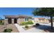 Charming single-story home featuring a tile roof, arched entryway, and vibrant yellow flowering bushes in the front yard at 20838 E Vía De Arboles --, Queen Creek, AZ 85142