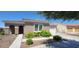 Charming single-story home featuring a tile roof, arched entryway, and vibrant yellow flowering bushes in the front yard at 20838 E Vía De Arboles --, Queen Creek, AZ 85142