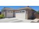 View of the three car garage with white doors and desert landscaping at side of home at 20838 E Vía De Arboles --, Queen Creek, AZ 85142