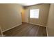 Bedroom features wood-look floors, neutral paint, a closet, and a bright window at 22320 W Morning Glory St, Buckeye, AZ 85326