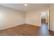 Spacious bedroom with wood-look flooring and view to staircase at 22320 W Morning Glory St, Buckeye, AZ 85326