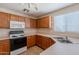Efficient kitchen featuring oak cabinetry, standard appliances, and ample countertop space near the stainless steel sink at 22320 W Morning Glory St, Buckeye, AZ 85326
